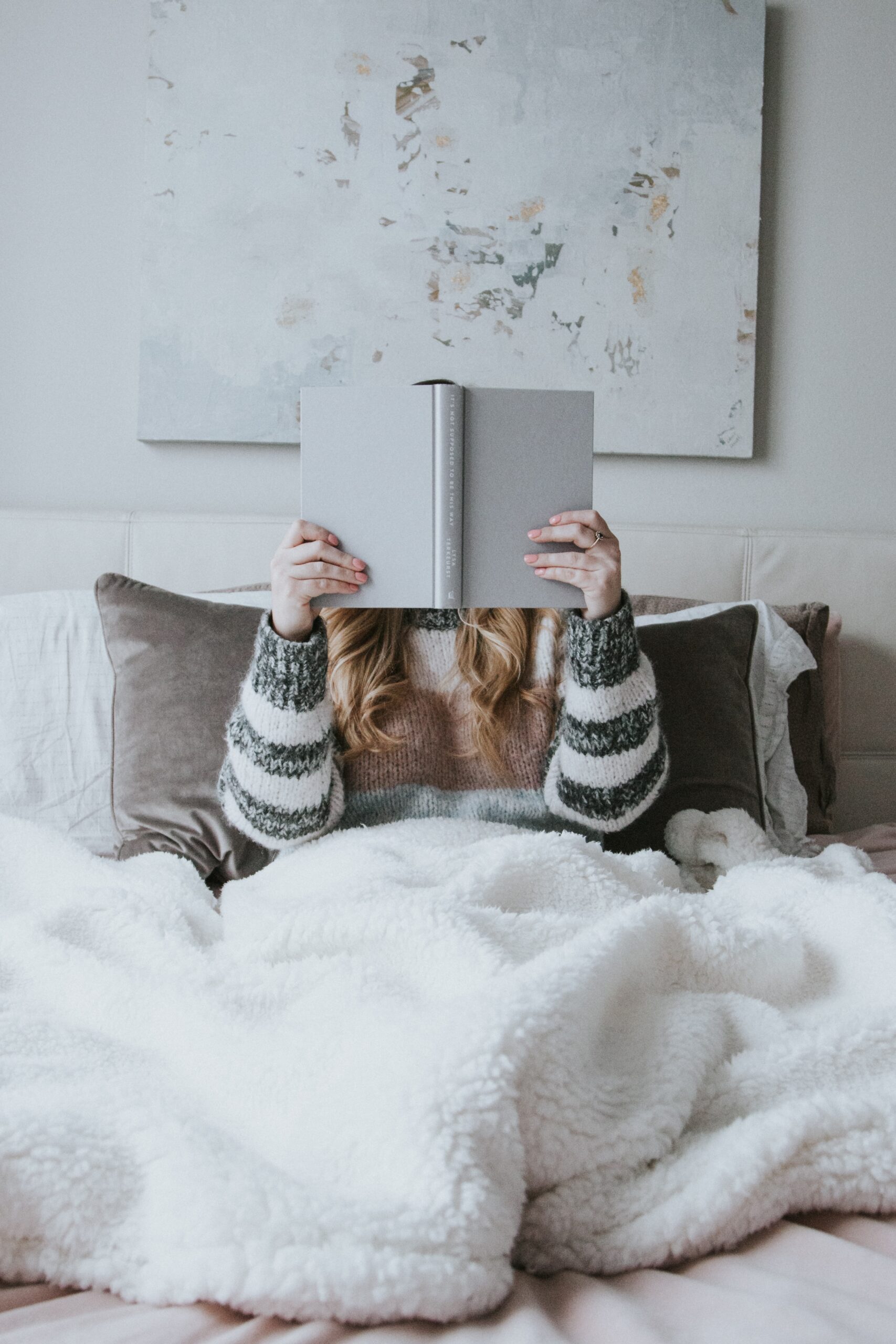girl reading book in cozy blanket